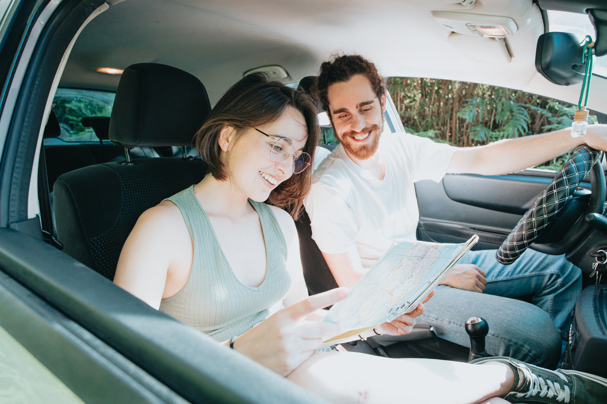 two-people-in-a-car-look-at-a-map-while-smiling.jpg